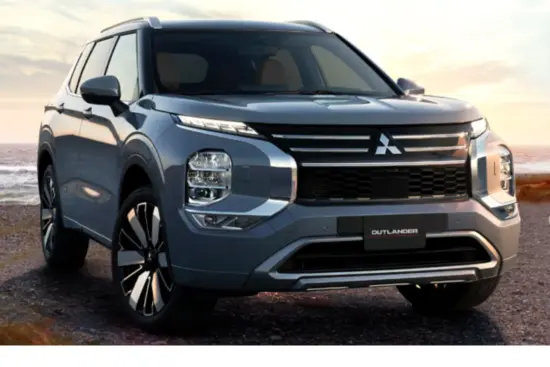 SUV Mitsubishi Outlander 2026 azul estacionada en una playa en el atardecer
