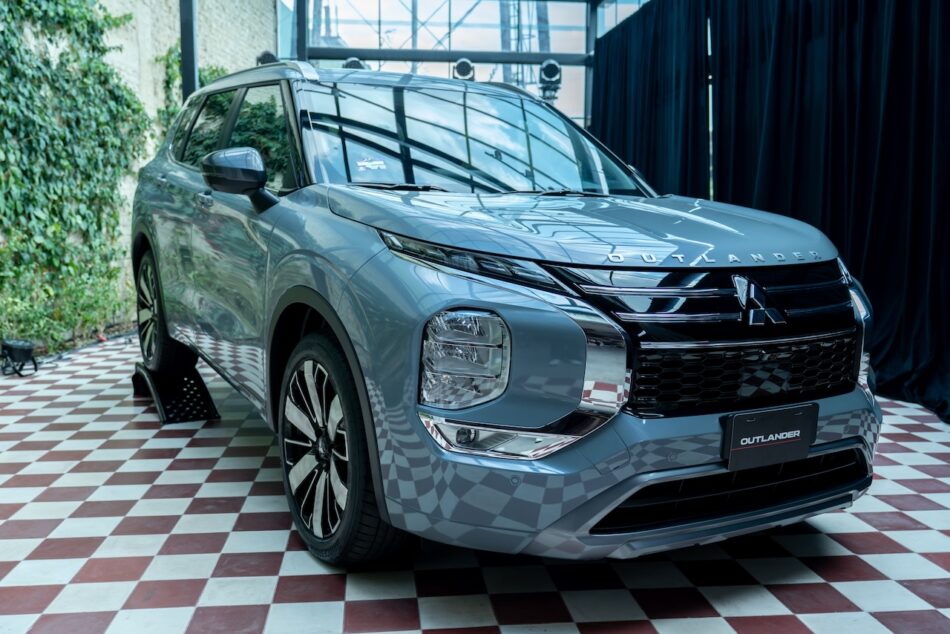 Vista frontal de la nueva Mitsubishi Outlander 2026 azul durante su presentación en salón mostrando parrilla renovada y faros LED estilizados