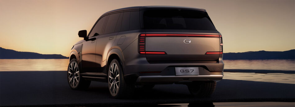 GAC apuesta por la electrificación en México con el nuevo GS7 PHEV Memo Lira Vista trasera de un SUV plateado GS7 estacionado junto a un lago tranquilo al atardecer con luces traseras iluminadas y ventanas tintadas oscuras