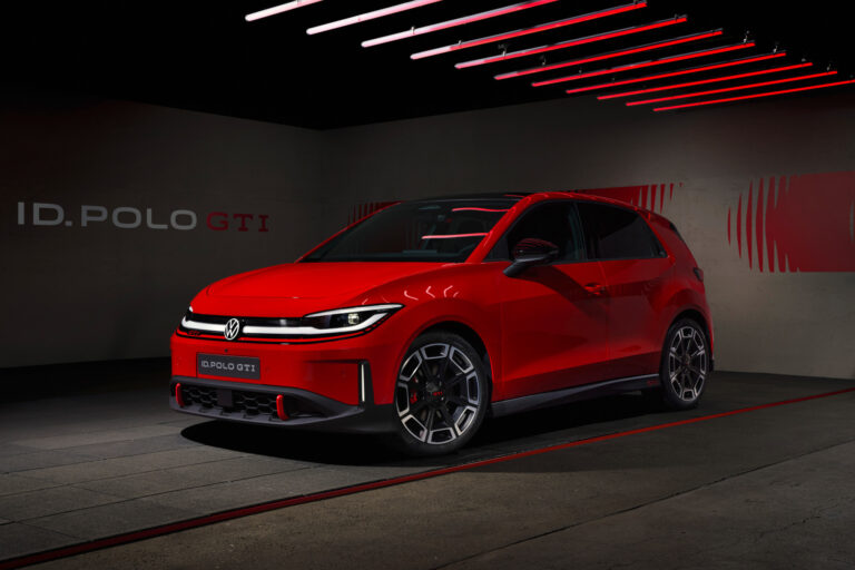Red Volkswagen ID. Polo GTI on display in a dark showroom with red neon light bars overhead.