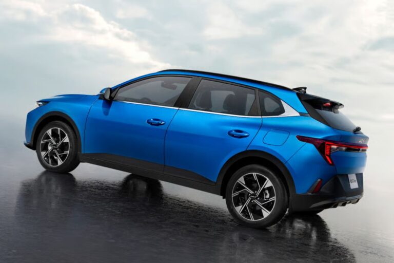 SUV compacto azul visto desde una perspectiva de tres cuartos trasera sobre una superficie mojada y reflectante, que destaca su diseño deportivo y sus llantas de aleación.