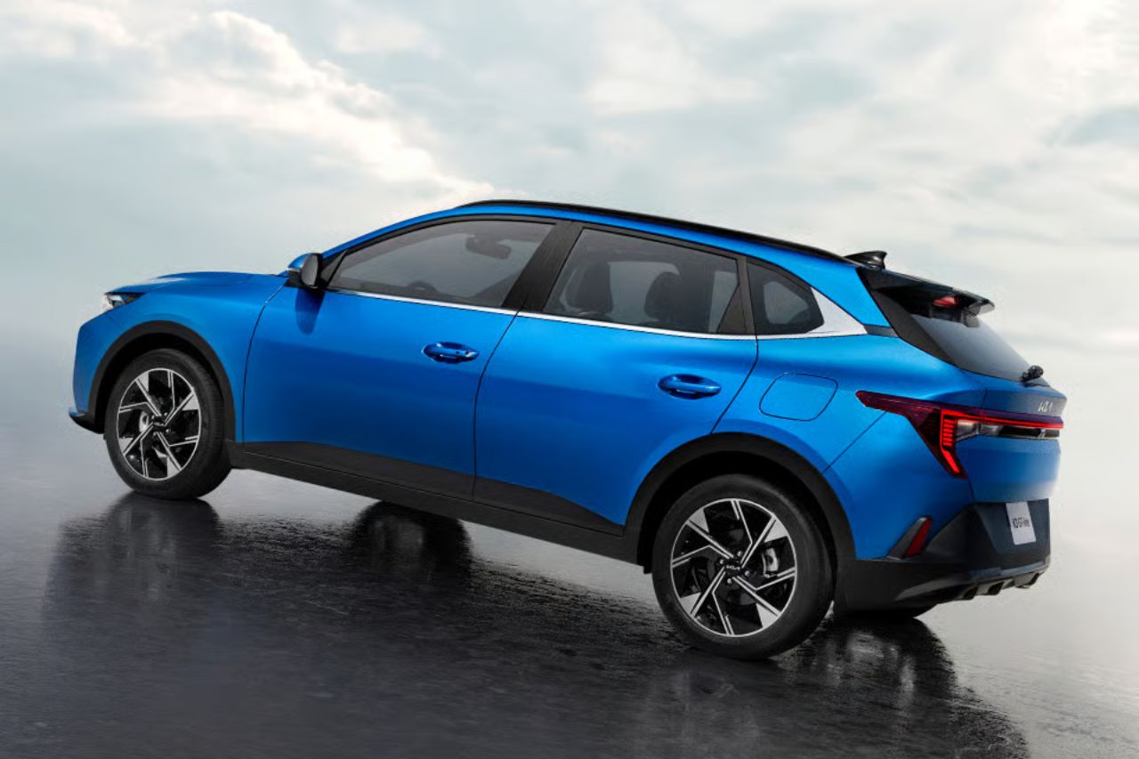 SUV compacto azul visto desde una perspectiva de tres cuartos trasera sobre una superficie mojada y reflectante, que destaca su diseño deportivo y sus llantas de aleación.