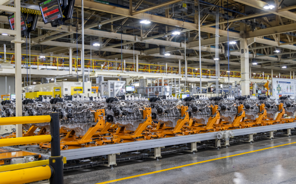 Planta de motores Stellantis Memo Lira Línea de producción con varios motores de coche montados sobre bastidores naranjas en una gran planta de fabricación