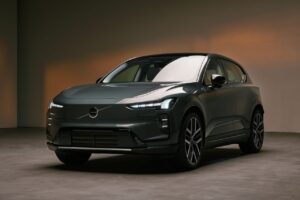 Vista frontal de tres cuartos de un SUV Volvo de color gris oscuro en una sala de exposición, en la que se aprecian sus elegantes faros LED