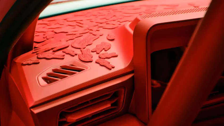 Red lit car interior with dozens of small cookie shapes scattered across the dashboard This image shows cookies spread out on the dashboard under red lighting inside a vehicle