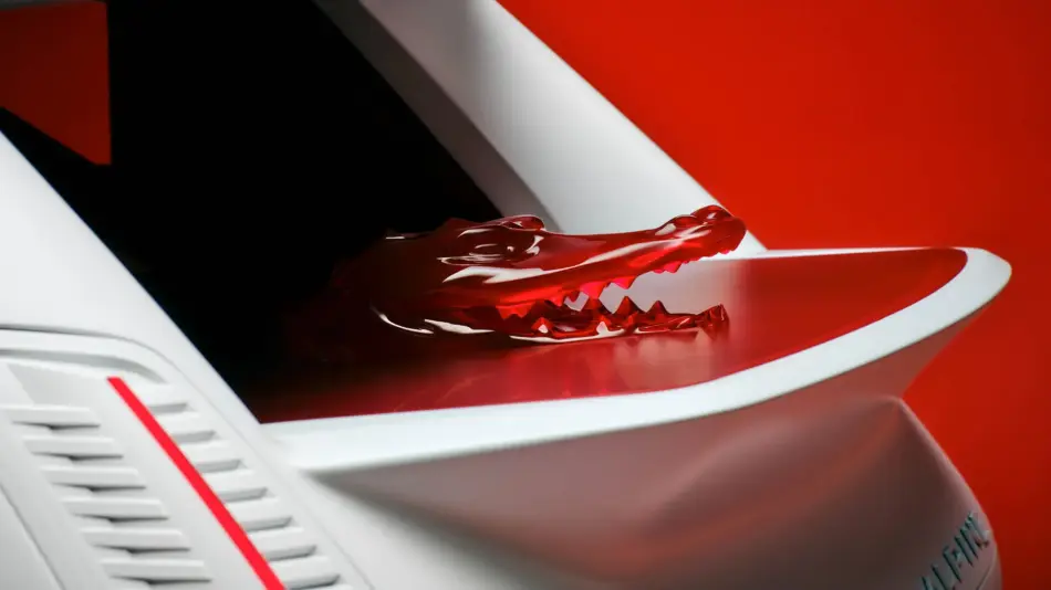 Close up of a red sculpted centerpiece on a white car hood against a red background emphasizing design detail and color contrast