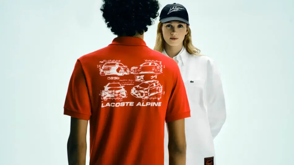 Back view of a person in a red Lacoste Alpine graphic polo facing another person in a white shirt and cap in a bright studio