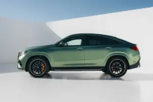 Perfil lateral de un SUV/crossover verde con llantas negras aparcado ante un fondo blanco de estudio.