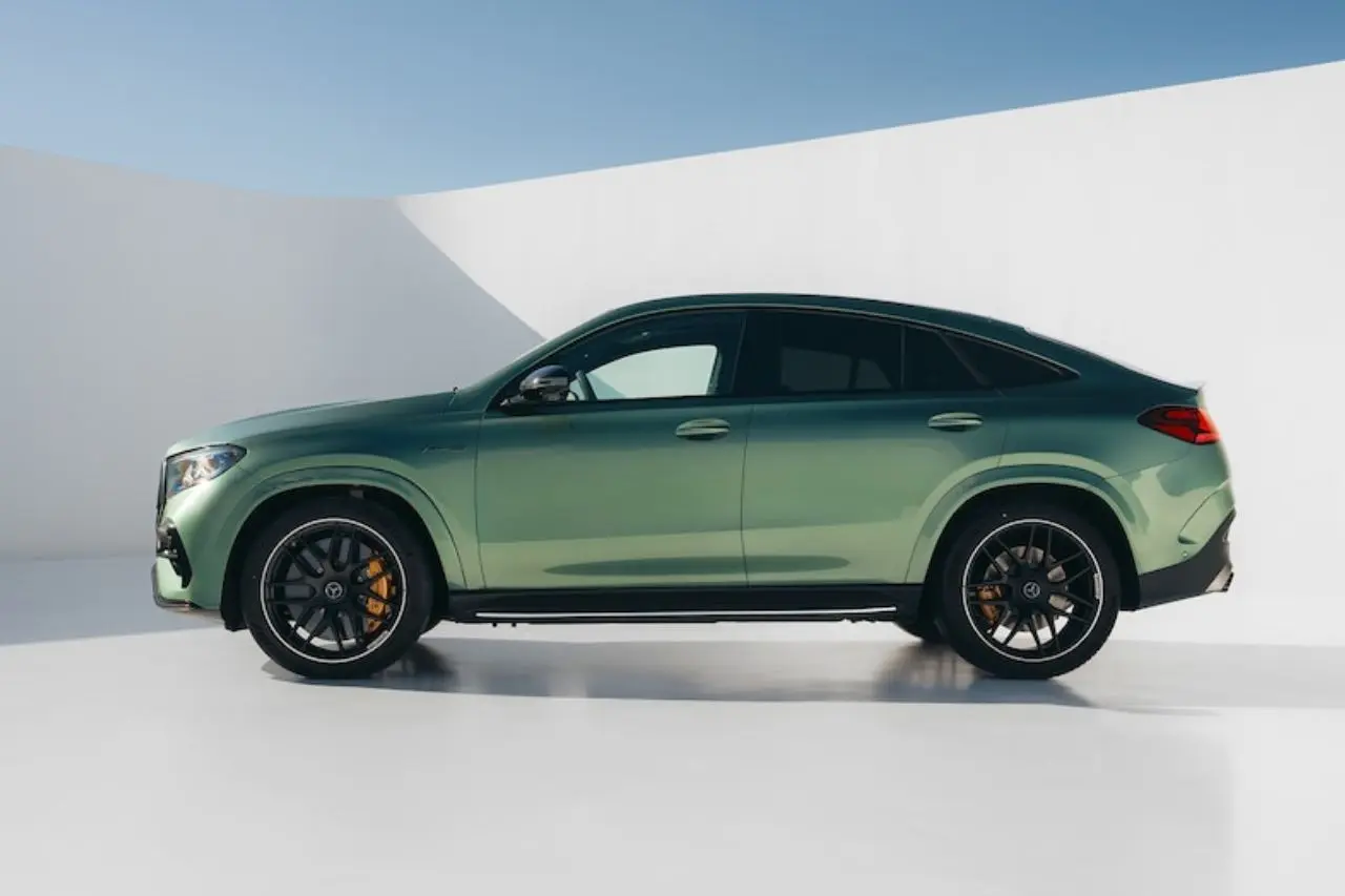 Perfil lateral de un SUV/crossover verde con llantas negras aparcado ante un fondo blanco de estudio.