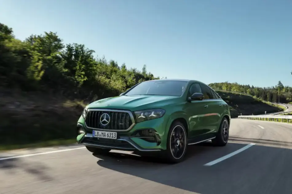 MercedesAMG GLE 63 S 4MATIC+7 Memo Lira Vista frontal de tres cuartos de un todoterreno Mercedes Benz verde circulando por una carretera sinuosa flanqueada por árboles en un día despejado luminoso y soleado