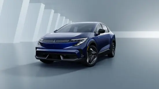 Blue electric SUV shown in a glossy studio setting with abstract white pillar shapes in the background.