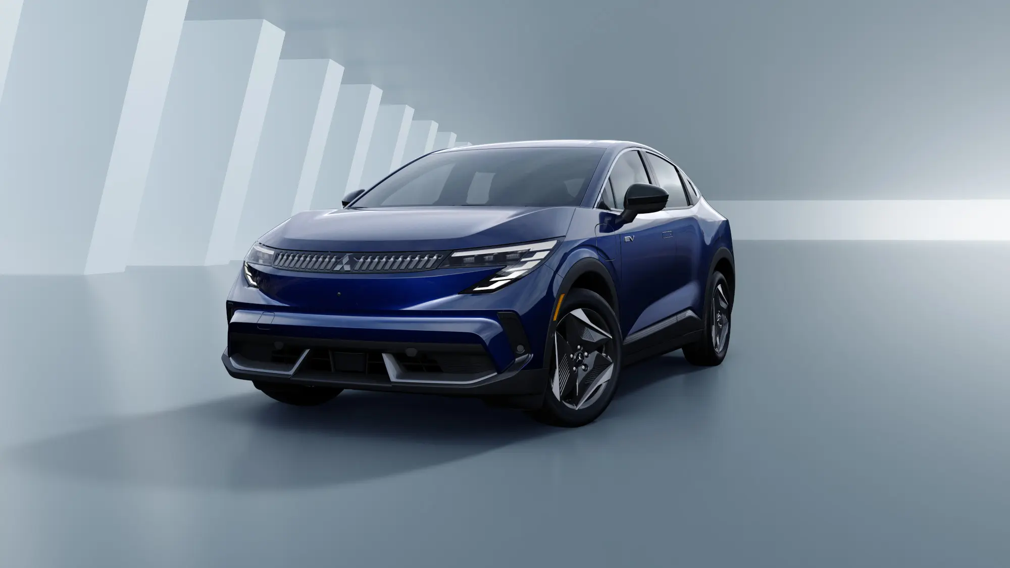 Blue electric SUV shown in a glossy studio setting with abstract white pillar shapes in the background.