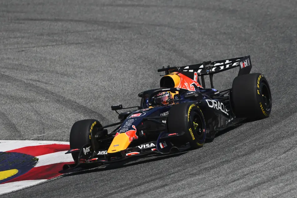 Red Bull Racing Formula 1 car speeding along a race track close to red and blue curbs