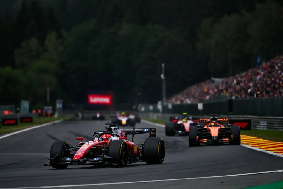 Kimi Antonelli vuelve a la cima en Spa y amplía su ventaja en el campeonato Memo Lira Formula 1 cars racing on a track with a red car leading sharp tires and sponsors visible a crowded grandstand to the right and a forested backdrop in the distance