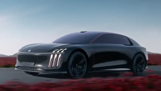 Sleek black futuristic car moving along a highway with a clear blue sky and red desert scrub in the background