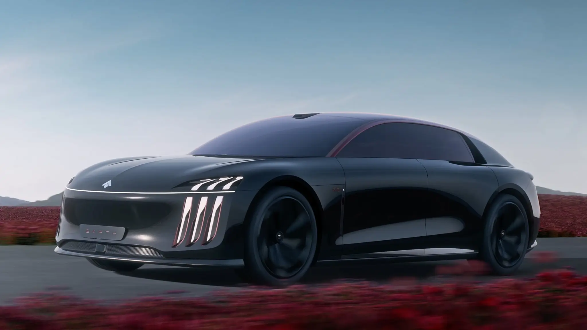 Sleek black futuristic car moving along a highway with a clear blue sky and red desert scrub in the background