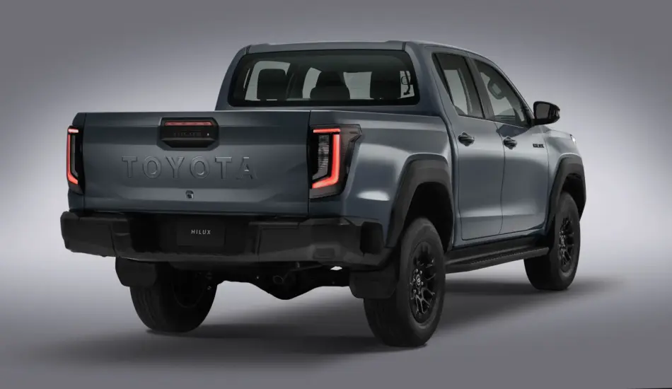 Toyota Hilux 2027 diseño renovado motores más eficientes y mayor seguridad Memo Lira Vista trasera de tres cuartos de una camioneta Toyota Hilux de doble cabina de color gris azulado con el portón trasero en el que se lee la inscripción TOYOTA