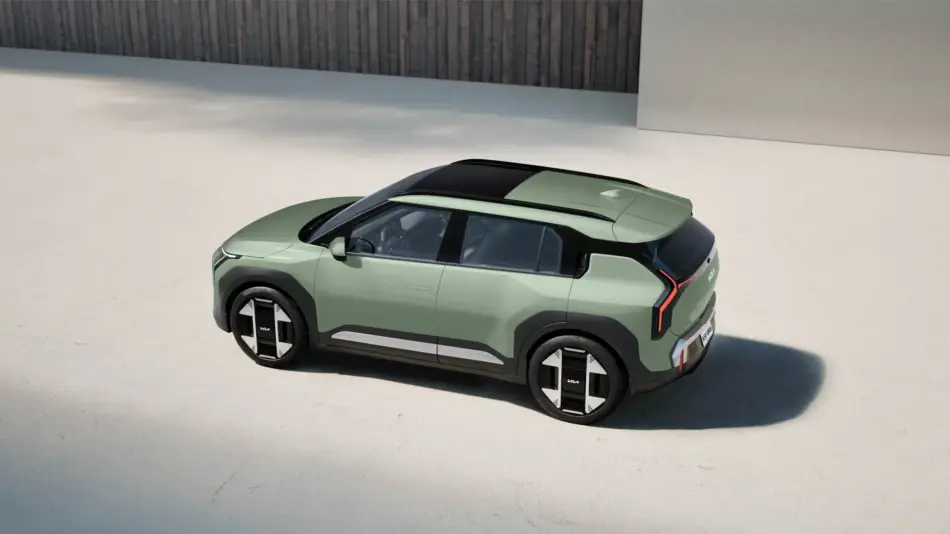 SUV conceptual ecológico con techo negro y luces traseras verticales rojas en un aparcamiento amplio y luminoso se aprecian los logotipos de la marca en las llantas y en el borde trasero Kia